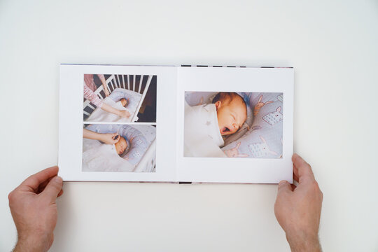 on white background, hands flip through photobook from home family photo shoot