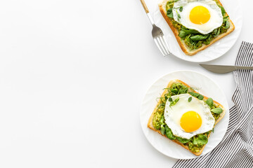 Breakfast with avocado toasts and fried eggs, top view