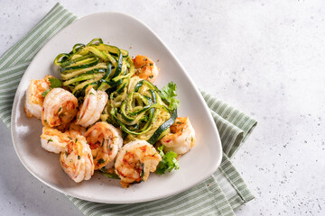 zucchini pasta with shrimps on white plate
