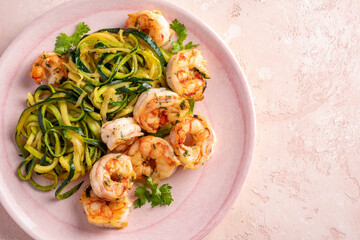 zucchini pasta with shrimps on white plate