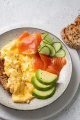 Ketogenic diet breakfast, scrambled eggs, salmon, avocado and cucumber