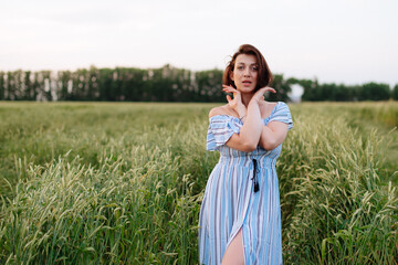 Beautiful young woman in summer in a wheat field