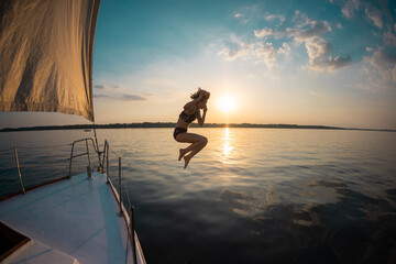 Girl jumping into the water from a yacht