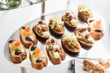 Beautiful catering banquet buffet table. Banquet service. Assorted bruschetta on white plate. High quality photo