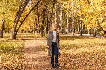 Obraz premium Woman in coat walking in autumn park.