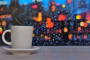 Obraz na płótnie Canvas Steaming coffee cup on a rainy day window background with copy space for text