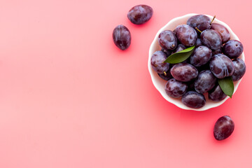 Food layout with plums in bowl with leaves. Top view
