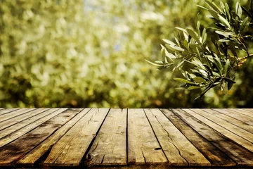 Türaufkleber Old wooden table  for product display with natural green olive field bokeh background. Natural vintage tabletop persepective and blur olive tree layout design. © hitdelight