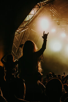 Silhouette of an unrecognizable woman having fun in a heavy metal concert