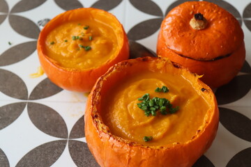 Curried butternut squash soup with coconut milk. Vegan pumpkin soup served in a squash shell. Eating healthy concept.  
