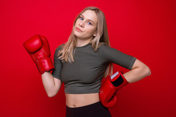 Sporty young woman posing in boxing gloves