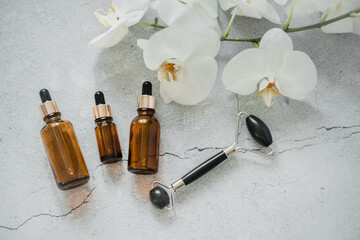 Serum or essential oil bottle with guasha massage roller for spa and natural skin care, body and...