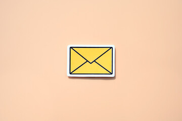 Yellow message sign or envelope against a salmon-colored background