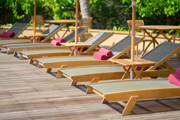 Beautiful tropical hotel resort with chairs in row and trees on back with warm sunny day