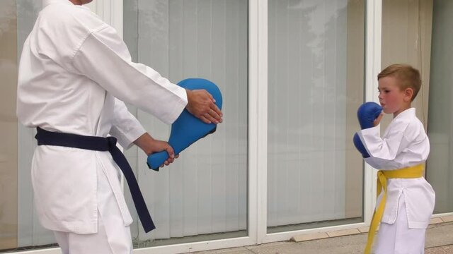 Boy training a circular kick on a blue trainer