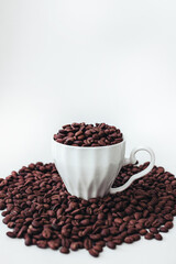 Cup with fresh aromatic roasted coffee beans isolated on white background. Cope space. Vertical