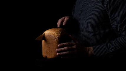 a man cuts freshly baked bread from premium flour