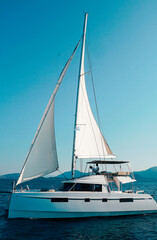 Fototapeta premium boat, sea, yacht, water, sail, sailboat, ocean, sailing, ship, sky, summer, travel, vacation, catamaran, horizon, holiday, nature, cruise, lake, vessel, beach, leisure, boats, wind, recreation, nautic