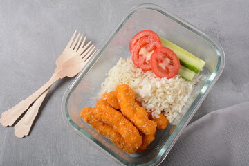 Chicken nuggets with rice and vegetables  on a white plate
