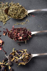 Various kinds of dry tea bancha green, Hibiscus, Butterfly Pea flower tea in spoons on the table