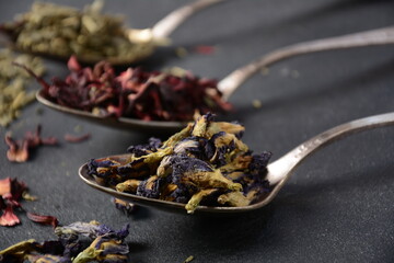 Various kinds of dry tea bancha green, Hibiscus, Butterfly Pea flower tea in spoons on the table