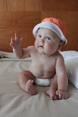 portrait of a cute lovely child boy sitting smiling in an orange hat