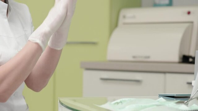 Dentist doctor putting on medical gloves in the dental office. High quality FullHD footage