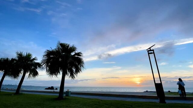 CHTAN-CHO, OKINAWA, JAPAN - JUNE 2021 : View of Araha beach (Ocean or sea) in sunset time. Wide view time lapse shot, dusk to night. Holiday, vacation and resort concept shot.