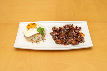 Filipino tocilog plate with bowl of overturned rice, fried egg and beef stew