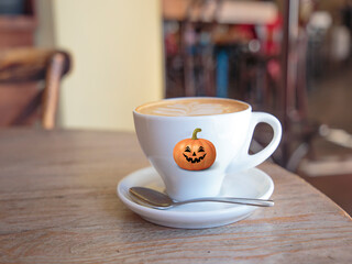 A happy Halloween Cup of coffee with a pumpkin spooky face 