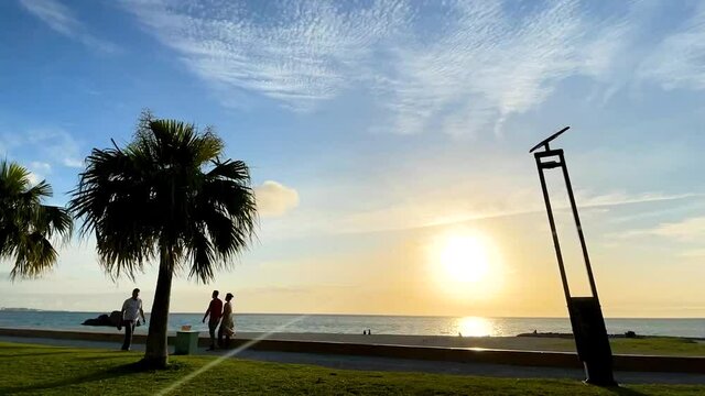 CHTAN-CHO, OKINAWA, JAPAN - JUNE 2021 : View of Araha beach (Ocean or sea) in sunset time. Wide view time lapse tracking shot, dusk to night. Holiday, vacation and resort concept shot.
