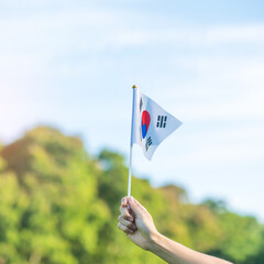 hand holding Korea flag on nature background. National Foundation, Gaecheonjeol, public Nation...