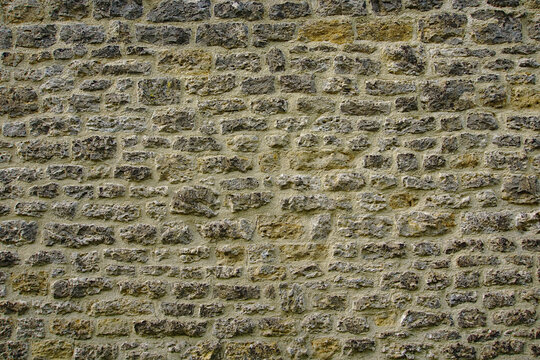 Brick wall background with yellow and black different-sized bricks