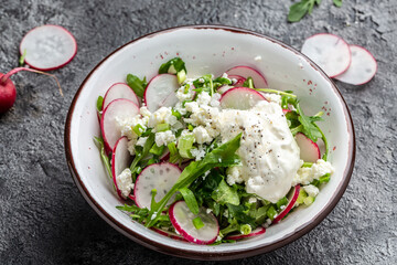 Vegetarian salad of radish, cottage cheese and arugula with sour cream. Healthy vegan food. banner, menu recipe place for text, top view