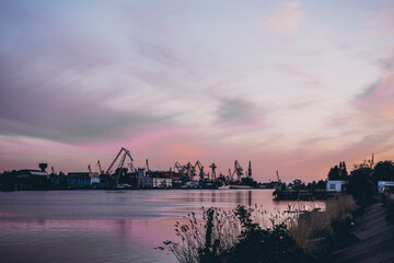 Naklejka premium ship cranes in the port at sunset