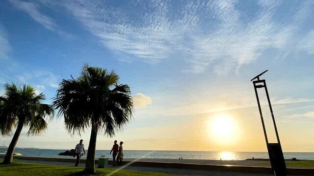 CHTAN-CHO, OKINAWA, JAPAN - JUNE 2021 : View of Araha beach (Ocean or sea) in sunset time. Wide view time lapse zoom out shot, dusk to night. Holiday, vacation and resort concept shot.