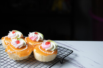 Vanilla orange cake with cream topping on marble table
