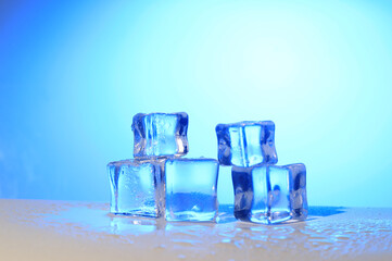 Photo of 5 wet artificial or fake ice cube at Blue Gradient background