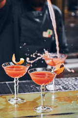 Cosmopolitan classic red cocktails in an elegant glass on the bar. High quality photo