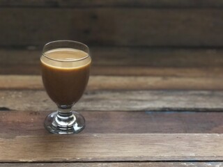Wine glasses has iced latte coffee on empty old wood table top,dimly light,free space for text design.Concept of Relaxation in Coffee time.