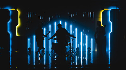 Four Man Rock Band with Lead Singer, Guitarists, Bassist and Drummer Performing at a Concert in a...