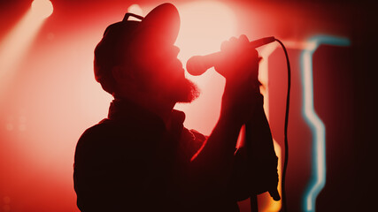 Rock Band Performing at a Concert in a Night Club. Portrait of a Lead Singer Singing into...