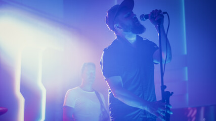 Rock Band Performing at a Concert in a Night Club. Portrait of a Lead Singer Singing into...