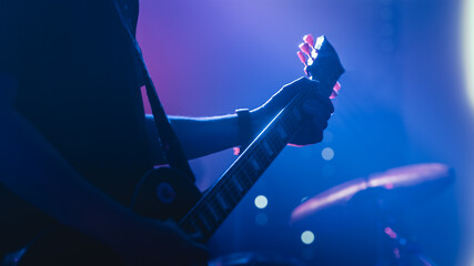 Rock Band Performing at a Concert in a Night Club. Close Up Shot of a Five String Bass Guitar...