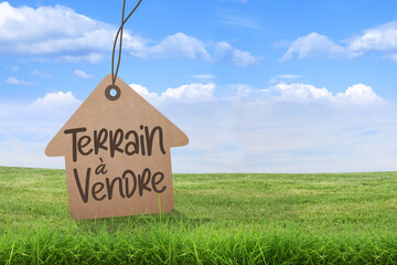 Terrain à vendre, affichage, signalisation sur fond herbe et ciel bleu