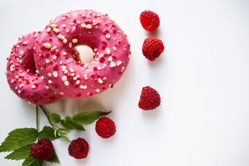 sweet dessert. round donuts with pink icing isolated on white background and raspberries 