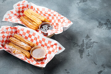 Churros take away in paper tray, on gray background with space for text, copyspace