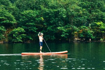 Happy active child on paddle board on water