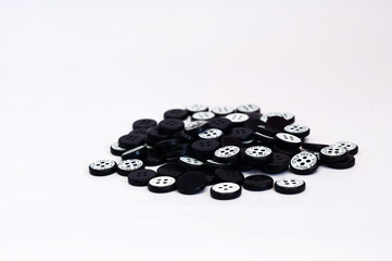 Simple black clothes button on white background with copy space.