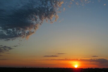 Fototapeta na wymiar Beautiful sunset over the field, the sun sets over the horizon